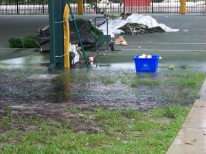 rain water pouring out of gutter on flooding soccer field