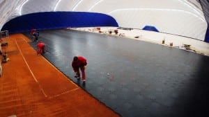 team installs ultrabasesystems panels to base of dirt tennis court