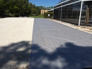 geosynthetic fabric rolled out onto compacted gravel area for backyard soccer installation