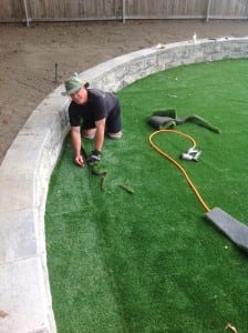 installer trimming artificial turf edge