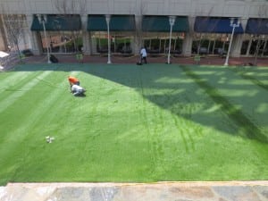 aerial view of installers adhering turf to panels