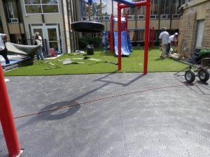 team installs synthetic turf on ultrabasesystems panel base for playground