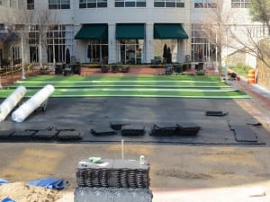 installing turf over ultrabasesystems panels with stacks of dirt and turf rolls