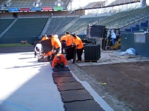 field installers unload and place ultrabasesystems panels for an artificial turf football field