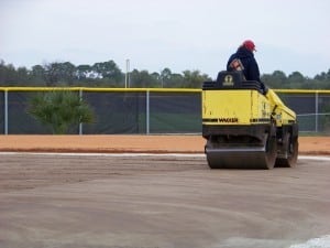 roller compacting dirt area for artificial turf field installation