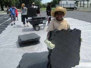 young boy carrying ultrabasesystems panels for soccer field installation