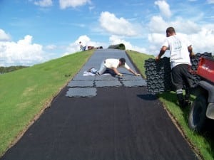 base panels laid out for tee line install while two men attach panels