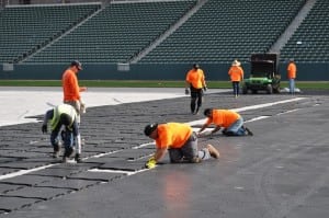 installers connect base panels together on football field installation