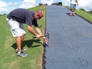 man nailing in ultrabasesystem panel on tee line