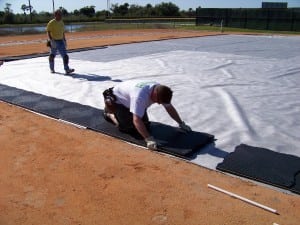 man lays down the first few base panels of artificial turf installation