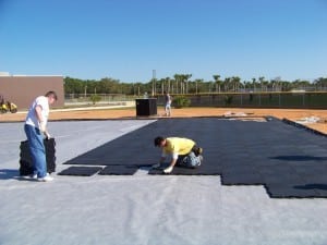 two men lay base panels on top of geo synthetic fabric