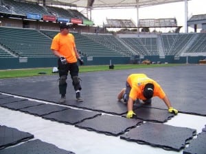 installers connect base panels together on football field installation