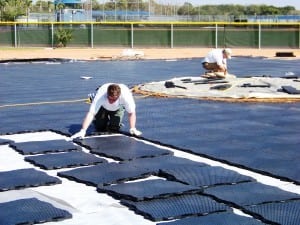 man installs a large area of base panels for artificial turf installation