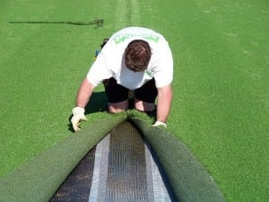 man connecting artificial turf with adhesive