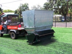 tractor pulling turfco infill applicator on newly installed artificial grass