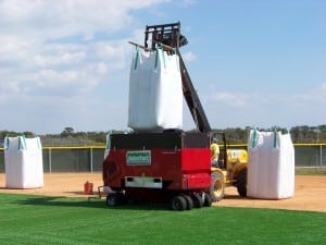 sand for astro turf is lifted by machine