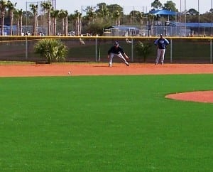 baseball players playing on artificial turf