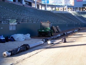 rolls of geotextile fabric are lined up for artificial football field turf installation