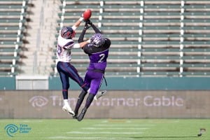two players up in the air trying to catch football