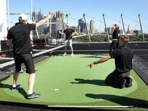 men playing on rooftop golf putting green in australia