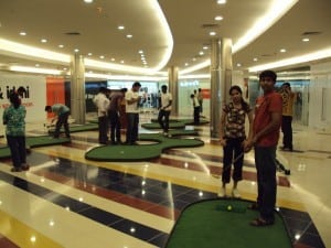 people putting on mini golf putting greens in indian mall