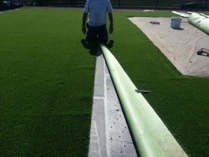 installer seaming two artificial turf pieces together