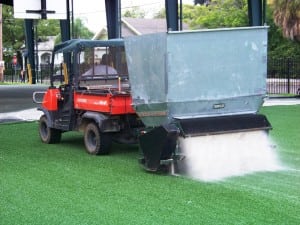 turfco tractor applying sand infill to artificial turf