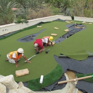 installers seaming two pieces of putting turf together