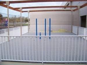 fenced playground area with playground panels installed