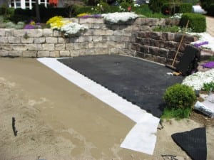 ultrabasesystems panels connected near stone wall for artificial lawn installation