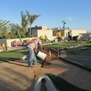 installer pouring dirt for rooftop golf installation