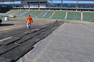 field installers pulling up and removing base panels from football field installation