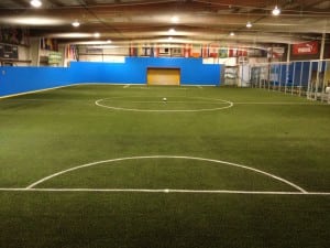 soccer ball in the middle of indoor artificial turf soccer field
