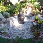 chairs and fire pit sitting on backyard paver installation
