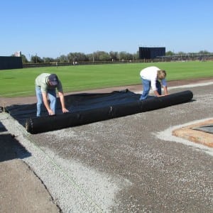 team rolls out geo textile fabric on gravel for Tampa Spring training complex