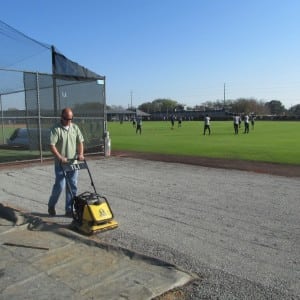 installer packing gravel to install baseball field turf