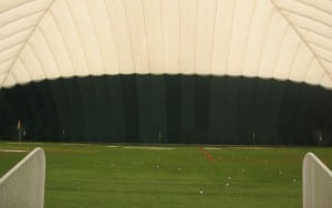 golf balls on indoor artificial putting green turf in sports dome