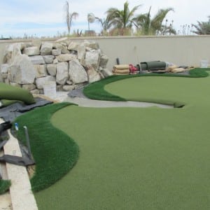 installed rooftop putting green with fringe next to pile of rocks