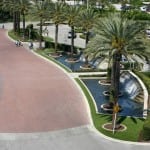 commercial artificial lawn turf installation near water feature and palm trees