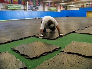 man lays down ultrabasesystems panel for indoor soccer field
