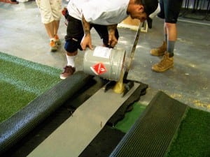 installers pour adhesive between two artificial turf pieces