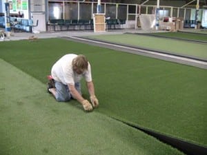 installer seams together two pieces of artificial turf