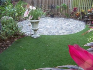 artificial lawn turf next to circle paver installation