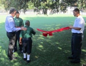 child cuts the ribbon of a newly finished artificial turf soccer field