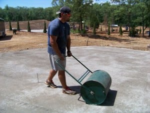 worker flattening gravel for artificial turf installation