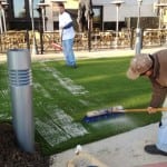 team spreads sand infill onto artificial lawn turf