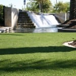 completed artificial lawn turf installation next to waterfall