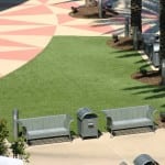 completed artificial lawn turf installation around benches and palm trees in Orlando mall
