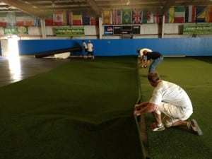 team laying down turf next to other artificial turf piece