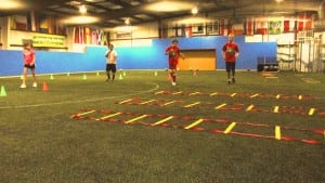 children practicing on indoor artificial turf soccer field